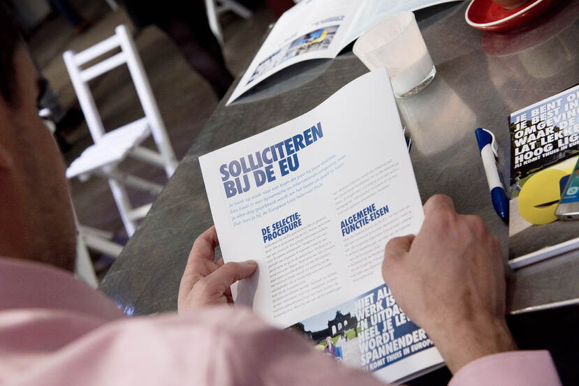 Man leest folder over solliciteren bij de EU